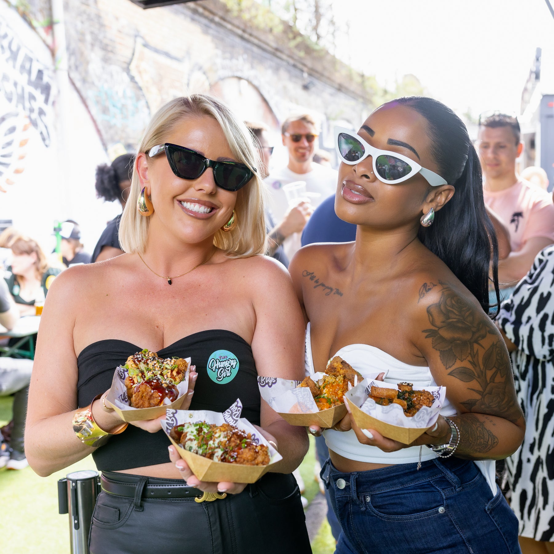 girls are having fun at wingjam, London Food Enthusiasts WingJam Festival 2024, WingJam London Food and Fun for All, Attendees Loving Chicken Wings at WingJam Festival London
