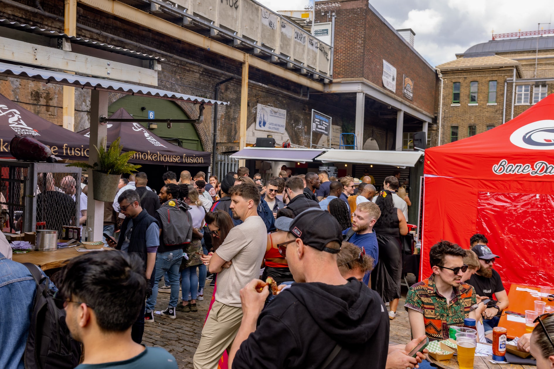 crowds gathered at Peckham Arches  for London's best chicken wing event - wingjam , WingJam London A Fun Day Out for Chicken Wing Fans, WingJam London Where the Best Wings and Friends Meet, WingJam London A Flavorful Gathering of Food Lovers, WingJam London Friends Relishing Every Chicken Wing, WingJam London A Festival for Wing Lovers and Foodies