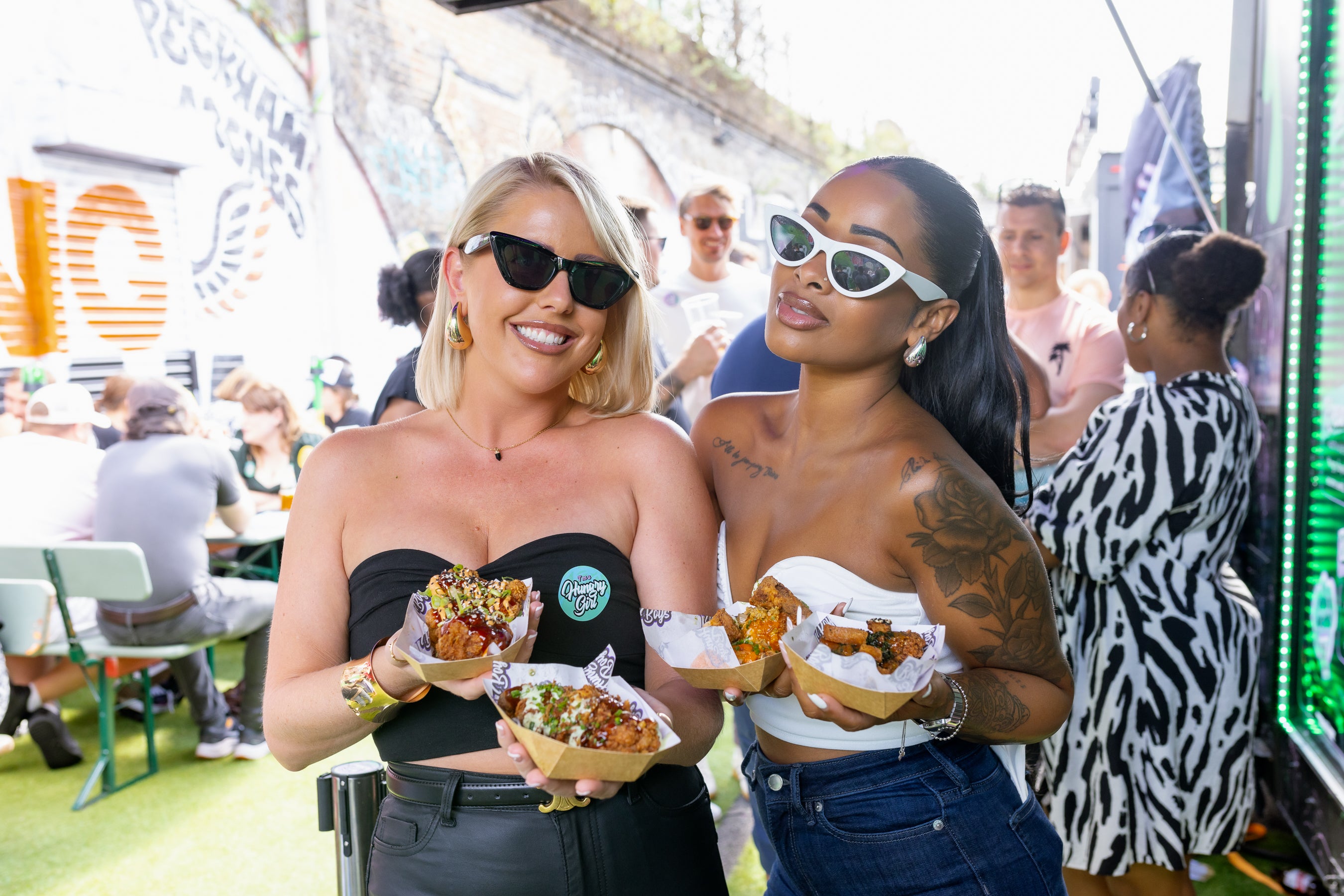 girls are having fun at wingjam, London Food Enthusiasts WingJam Festival 2024, WingJam London Food and Fun for All, Attendees Loving Chicken Wings at WingJam Festival London