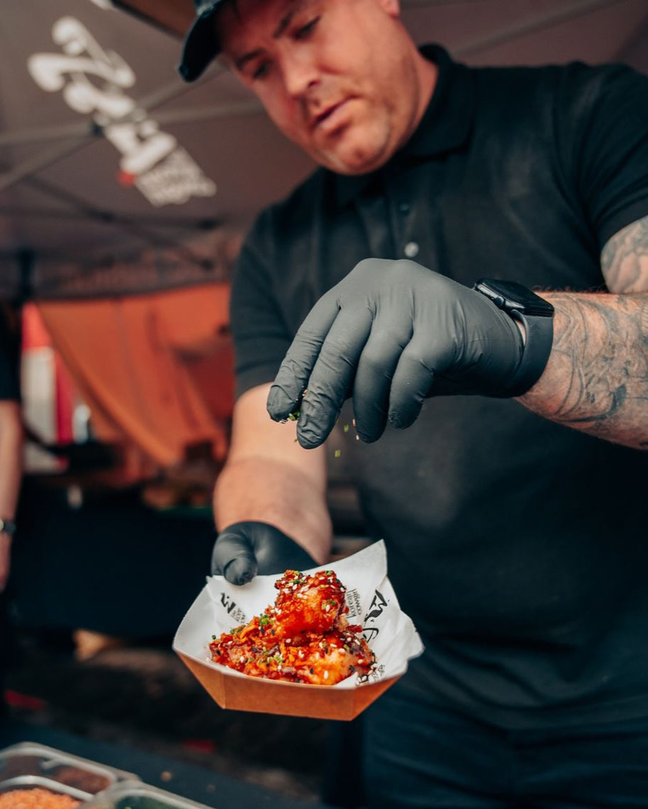 korean cowgirl's chef John bungle is garnishing wings at wingjam London, WingJam London A Fun and Flavorful Gathering of Friends, WingJam London People Relishing Every Wing Bite at the Festival, WingJam London A Celebration of Chicken Wings and Good Times, WingJam London The Ultimate Wing Lover’s Event for Friends, WingJam London A Fun Day Out for Food Lovers and Friends, WingJam London Where Flavor and Friendship Meet Over Wings, WingJam London A Celebration of Delicious Wings with Friends, WingJam London 